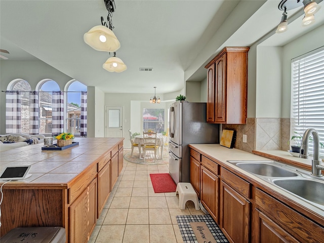 3115 Reagenea Dr, Wylie, TX 75098 - kitchen with tile countertops, visible vents, a wealth of natural light, and a sink