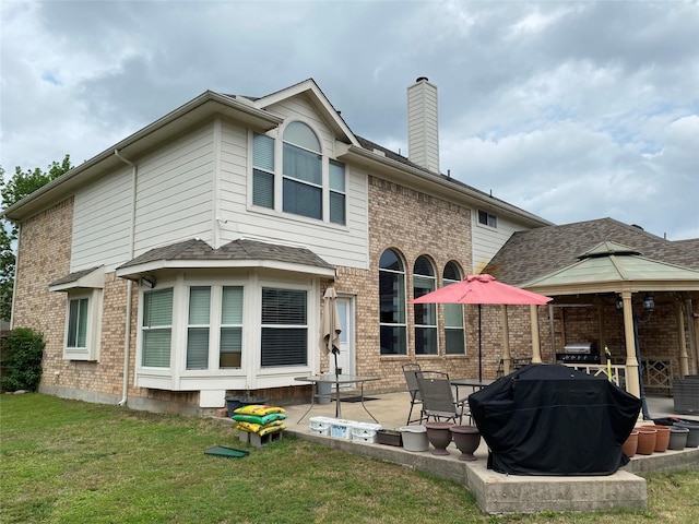 3115 Reagenea Dr, Wylie, TX 75098 - rear view of property with a chimney, a lawn, brick siding, a gazebo, and a patio