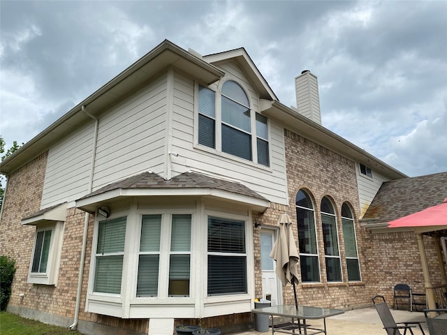 3115 Reagenea Dr, Wylie, TX 75098 - view of home's exterior with brick siding, a patio area, and a chimney