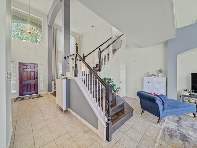 3115 Reagenea Dr, Wylie, TX 75098 - entrance foyer featuring stairs, a notable chandelier, light tile patterned floors, and a towering ceiling
