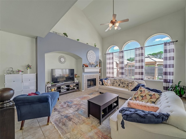 3115 Reagenea Dr, Wylie, TX 75098 - living area featuring a tiled fireplace, a ceiling fan, light tile patterned flooring, and high vaulted ceiling