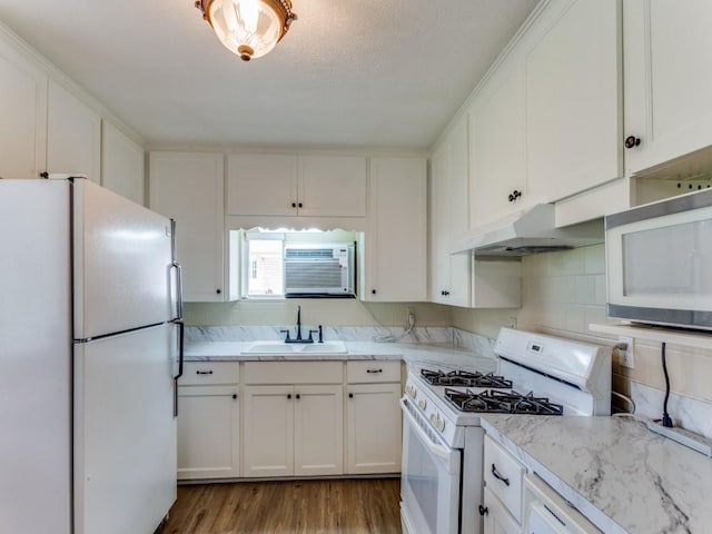 kitchen featuring white cabinets, white appliances, under cabinet range hood, and a sink