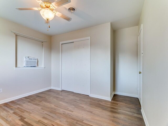 unfurnished bedroom featuring baseboards, light wood-type flooring, and a closet