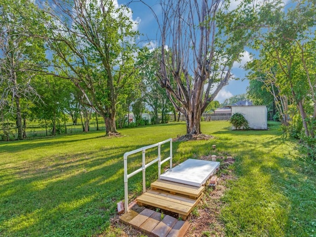 view of yard featuring fence and an outbuilding