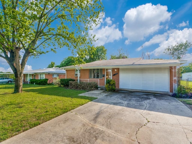 ranch-style house featuring concrete driveway, a front yard, an attached garage, a porch, and brick siding