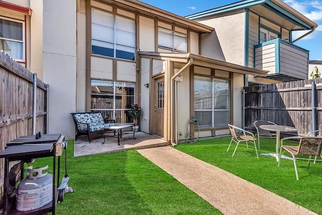 back of property with a patio, a lawn, stucco siding, and fence