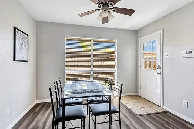 dining area featuring baseboards, wood finished floors, and ceiling fan