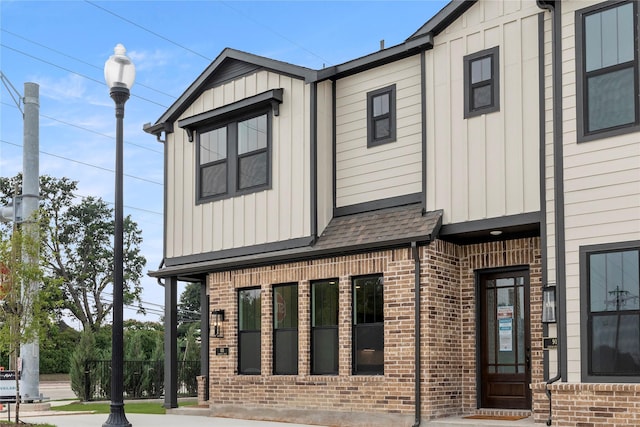 921 Janwood, Plano, TX 75075 - view of side of home with brick siding, board and batten siding, and a shingled roof