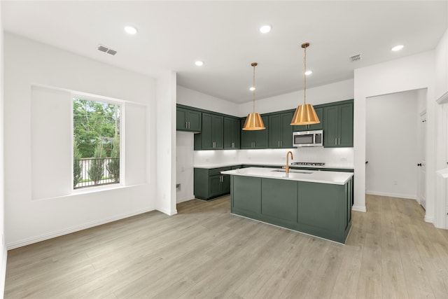 921 Janwood, Plano, TX 75075 - kitchen featuring green cabinets, stainless steel microwave, light countertops, a sink, and light wood-style flooring