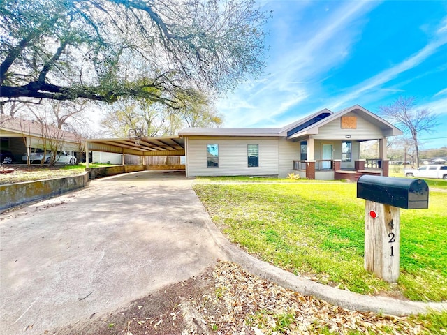 ranch-style home with concrete driveway, a porch, and a front lawn