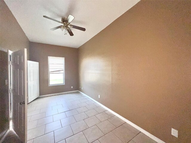 spare room featuring baseboards, ceiling fan, and tile patterned flooring
