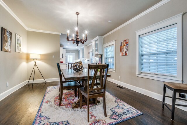 dining room with a chandelier, crown molding, baseboards, visible vents, and dark wood-type flooring