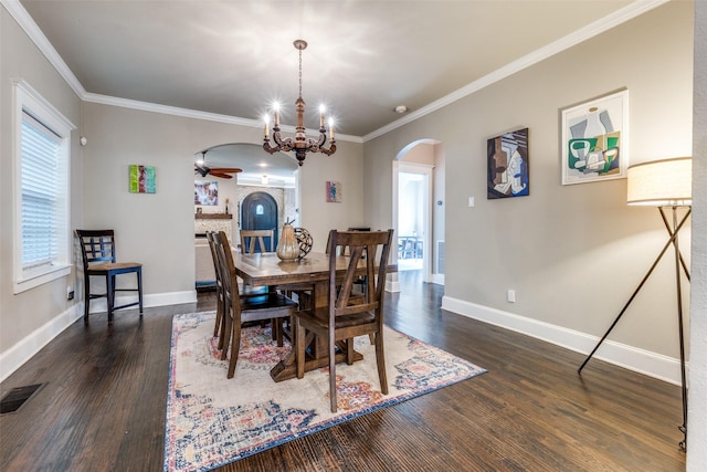 dining room featuring dark wood-style floors, baseboards, and arched walkways