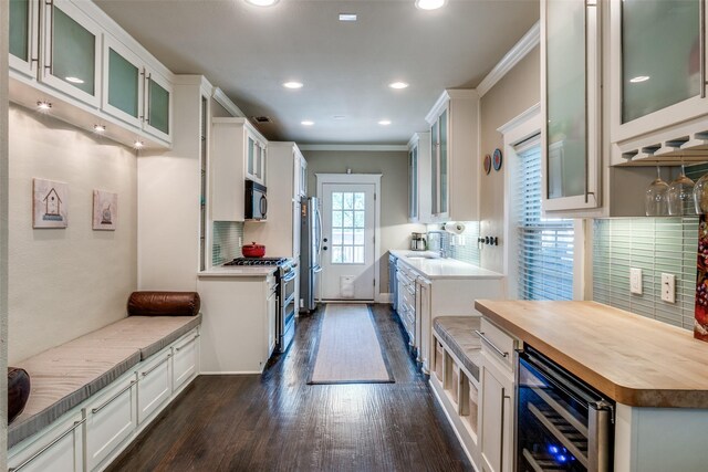 kitchen featuring white cabinetry, stainless steel appliances, butcher block counters, dark wood-type flooring, and wine cooler