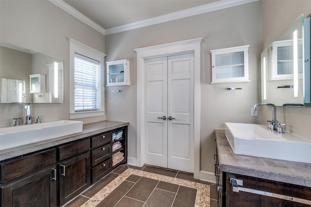 bathroom featuring tile patterned floors, two vanities, crown molding, and a sink
