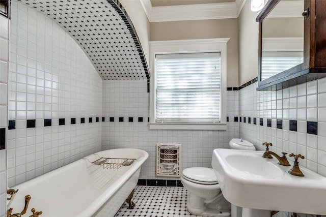 full bath with heating unit, toilet, a freestanding bath, and tile walls