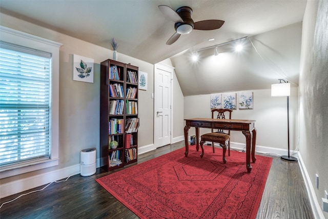 office space featuring rail lighting, vaulted ceiling, dark wood-style flooring, baseboards, and a ceiling fan