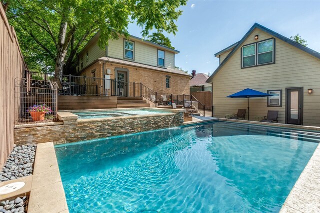 view of pool with fence, a fenced in pool, and an in ground hot tub