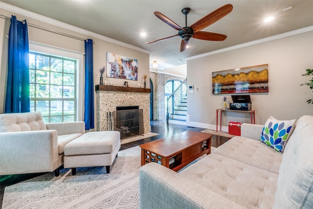 living room featuring wood finished floors, a ceiling fan, a fireplace with flush hearth, and plenty of natural light