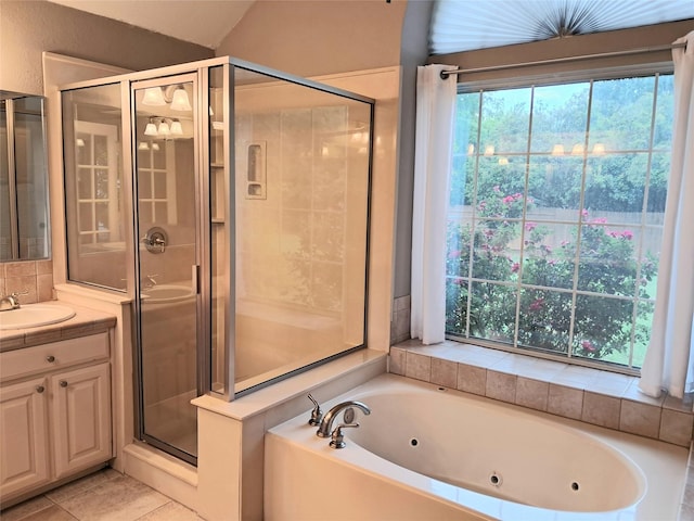 bathroom with a tub with jets, tile patterned floors, a shower stall, and vanity