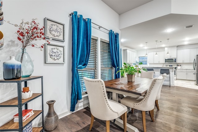 dining room featuring baseboards, visible vents, and wood finished floors