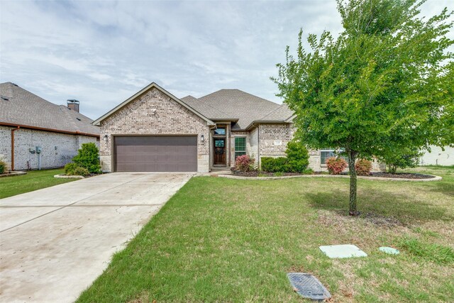 french country inspired facade with a garage, brick siding, a front yard, and concrete driveway