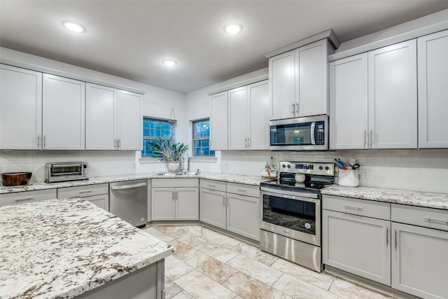 kitchen featuring recessed lighting, a sink, tasteful backsplash, a toaster, and appliances with stainless steel finishes