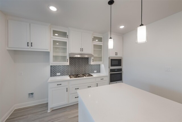 kitchen featuring light wood-style flooring, white cabinets, appliances with stainless steel finishes, and tasteful backsplash