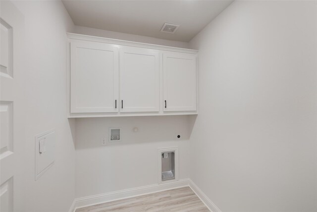 laundry room featuring hookup for a gas dryer, electric dryer hookup, visible vents, cabinet space, and light wood finished floors