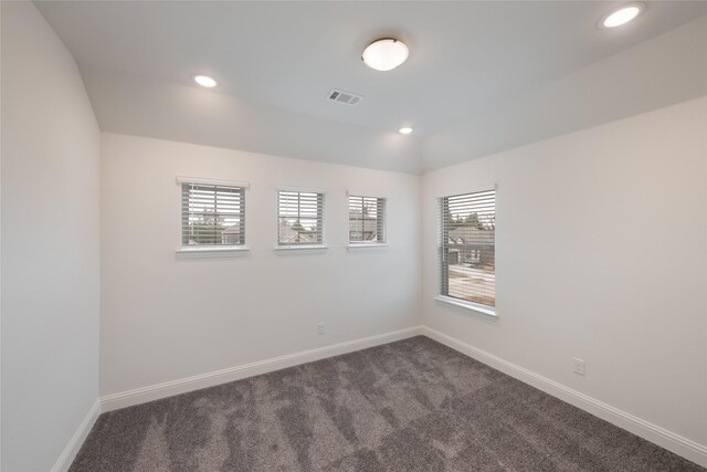 empty room featuring baseboards, visible vents, dark carpet, and recessed lighting
