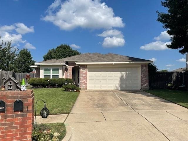 ranch-style house with driveway, a front yard, an attached garage, and brick siding