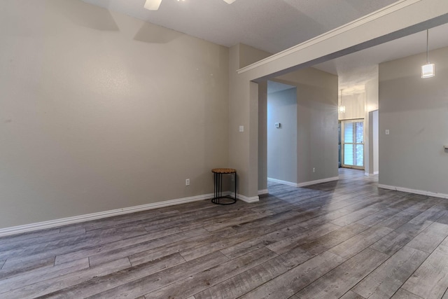 unfurnished room with a ceiling fan, dark wood-style flooring, and baseboards