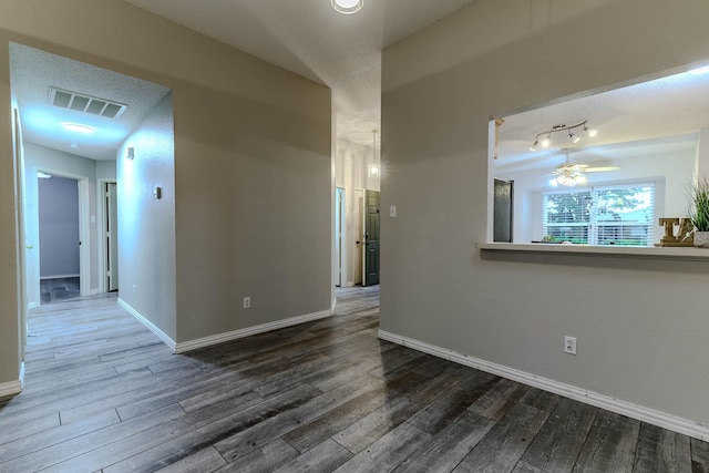 unfurnished room featuring visible vents, a ceiling fan, and dark wood-style flooring