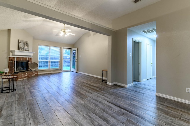 unfurnished living room with a ceiling fan, visible vents, dark wood-style flooring, and a textured ceiling