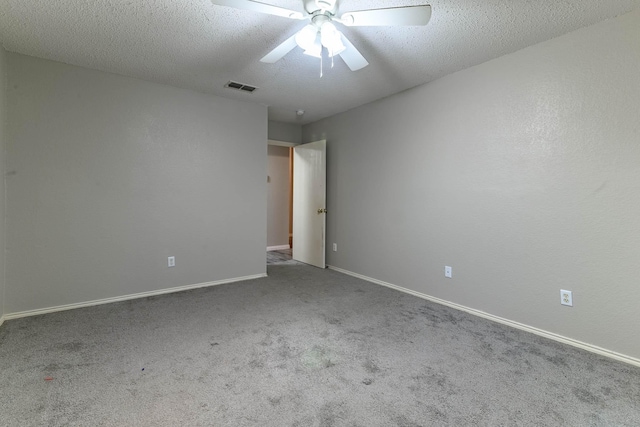 carpeted empty room with baseboards, visible vents, ceiling fan, and a textured ceiling