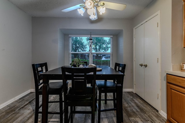 dining space featuring dark wood-style flooring, a ceiling fan, and a textured ceiling