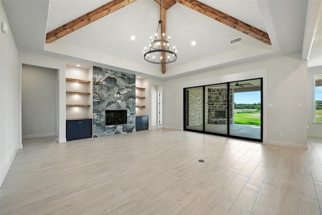 165 Rio Rancho Dr, Decatur, TX 76234 - unfurnished living room with a chandelier, built in features, a premium fireplace, light wood-style flooring, and a raised ceiling