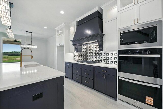 165 Rio Rancho Dr, Decatur, TX 76234 - kitchen featuring stainless steel appliances, tasteful backsplash, white cabinetry, glass insert cabinets, and custom range hood