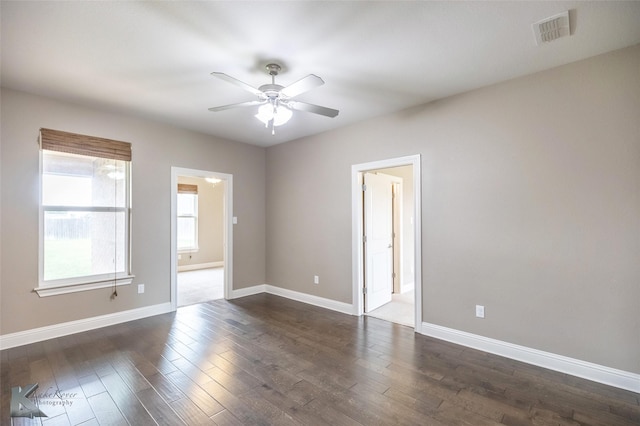 unfurnished room with visible vents, ceiling fan, dark wood-style flooring, and baseboards
