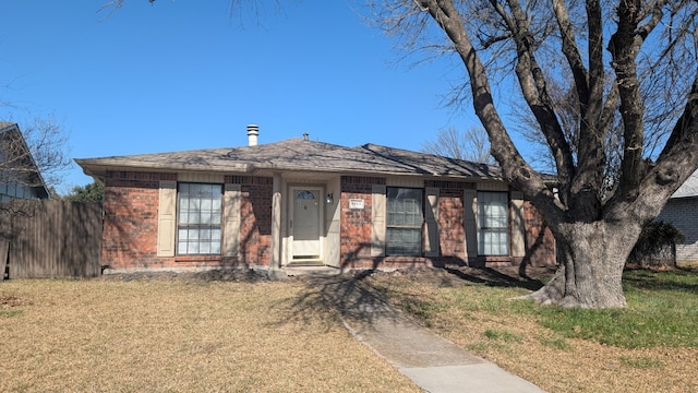 view of front of house featuring a front yard, fence, and brick siding