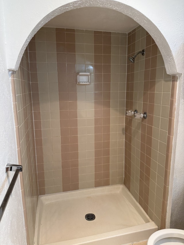 full bathroom with a stall shower and a textured wall