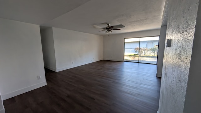 empty room with dark wood-type flooring, ceiling fan, and baseboards
