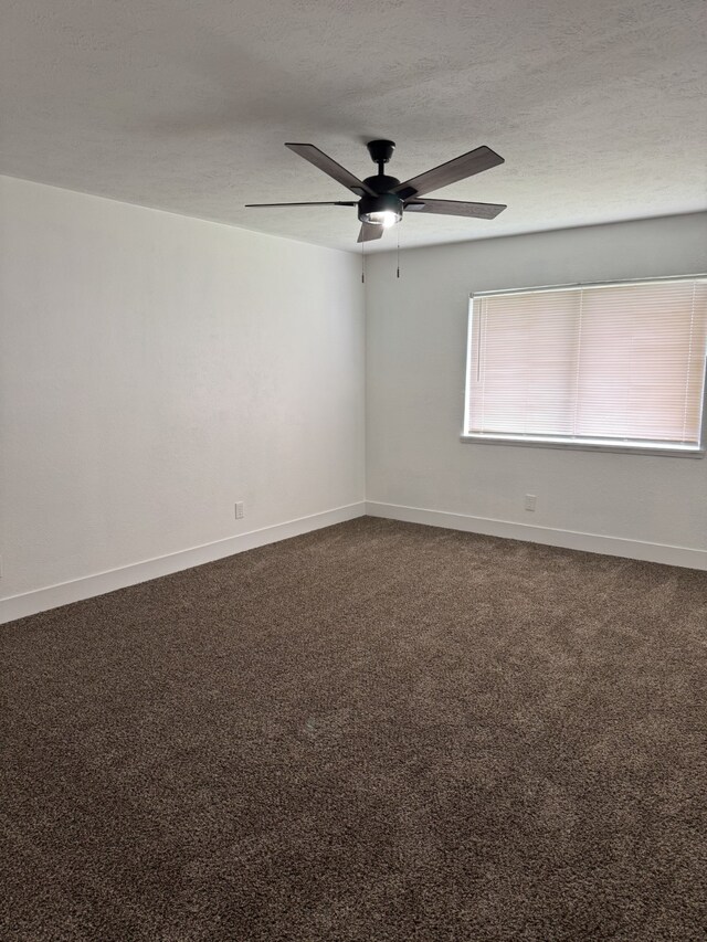 unfurnished room featuring dark carpet, a textured ceiling, ceiling fan, and baseboards