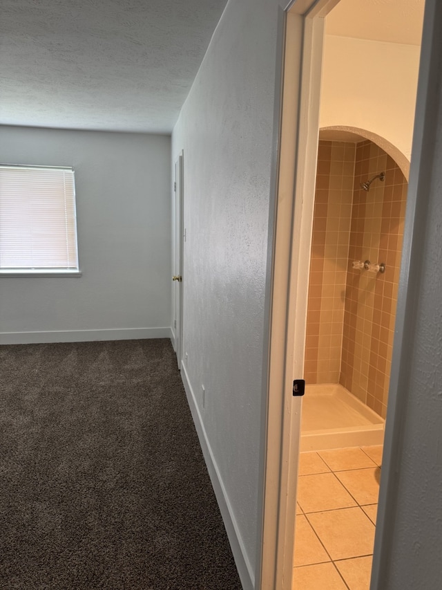 corridor featuring baseboards and arched walkways