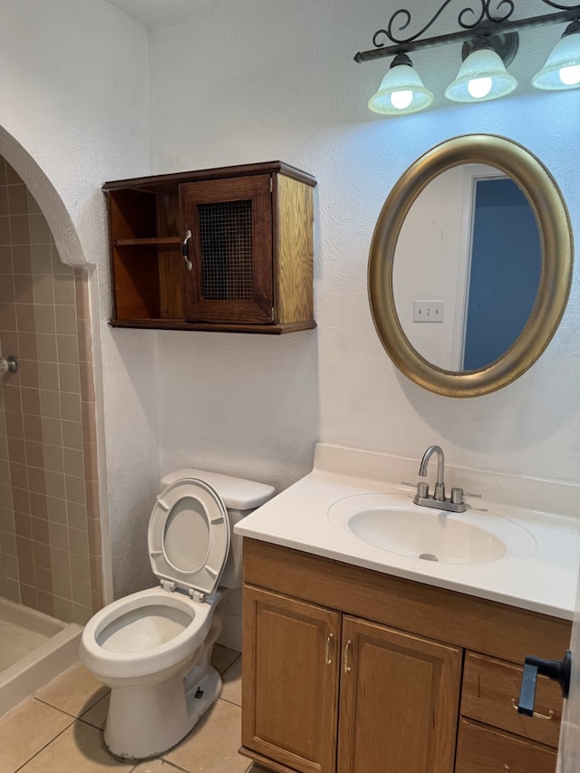 bathroom featuring toilet, vanity, tile patterned floors, and a stall shower