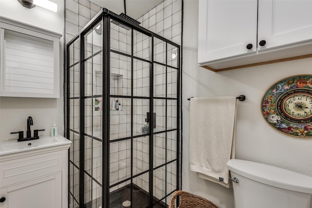 bathroom featuring a stall shower, toilet, and vanity