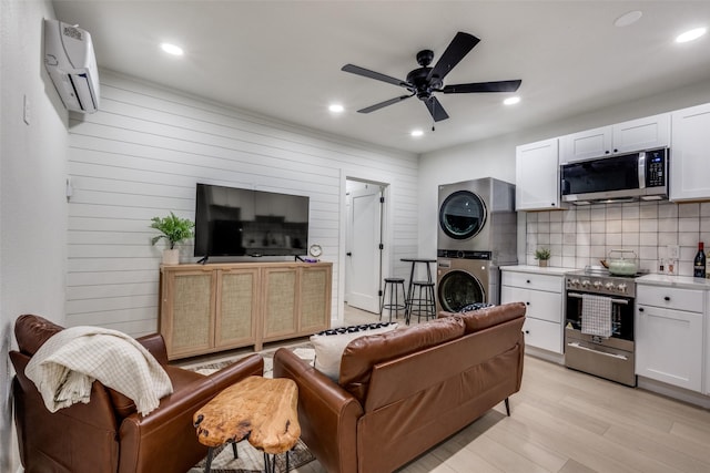 521 Texas St, Denton, TX 76209 - living area with stacked washer / dryer, a wall mounted air conditioner, ceiling fan, recessed lighting, and light wood finished floors