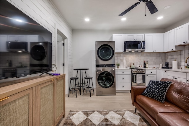 521 Texas St, Denton, TX 76209 - kitchen featuring oven, stacked washing maching and dryer, ceiling fan, stainless steel microwave, and a sink