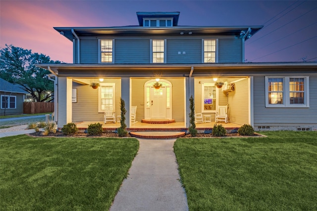 traditional style home with a lawn and covered porch