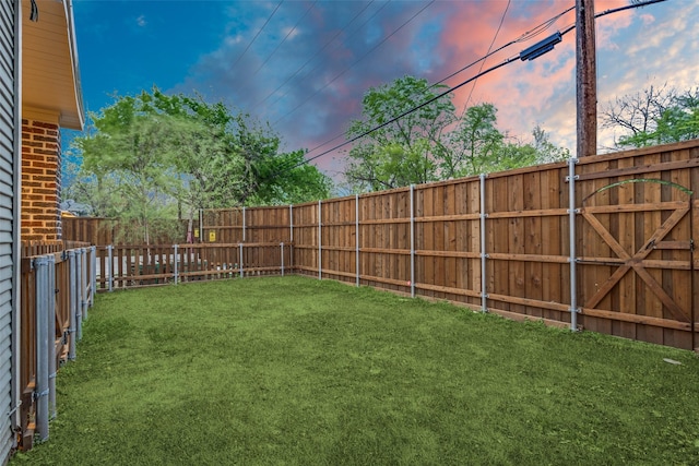 yard at dusk with a fenced backyard